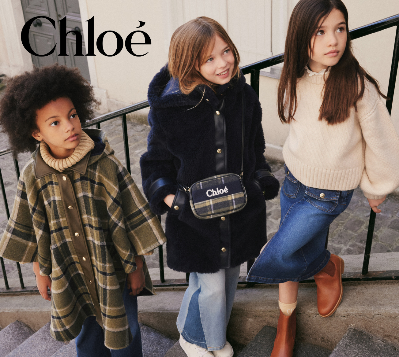 Three children wearing Chloé clothing standing on steps.